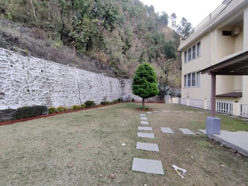 a tree in a yard next to a building at DreamCatcher By Samyati Hotels and Resorts in Bhīm Tāl