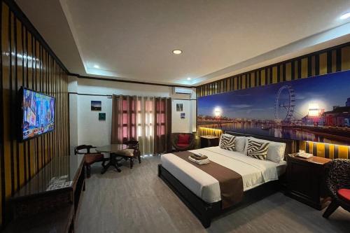 a hotel room with a bed and a large painting on the wall at Angeles Palace Hotel in Angeles