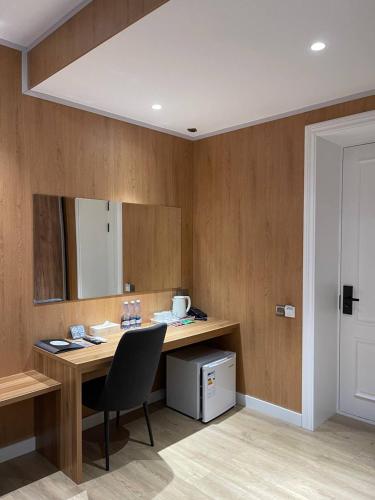 a room with a desk with a chair and a mirror at WELLFORT HOTEL in Samarkand