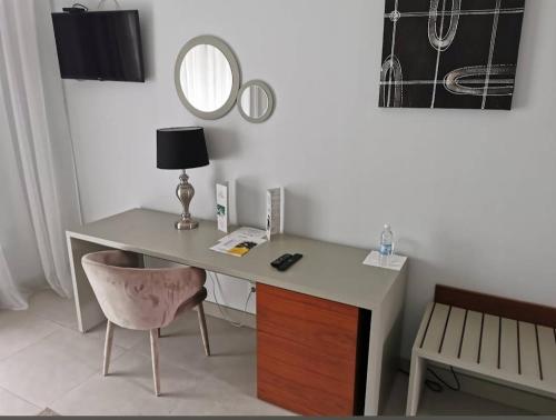 a desk with a chair and a mirror on a wall at Hôtel Ribadou Garoua in Garoua