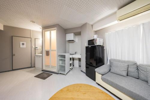 a living room with a couch and a kitchen at Roppongi 3min Walk, Shinjuku 10min,Shibuya 15min, Tokyo Tower 58sqm for 6 in Tokyo