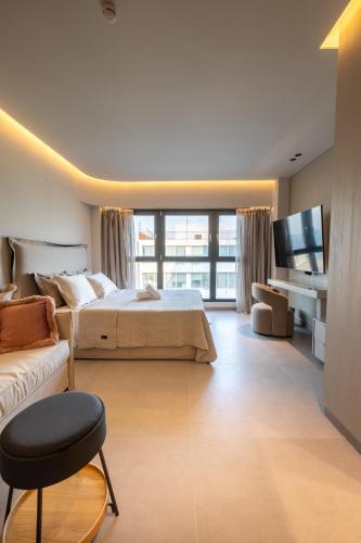 a bedroom with a bed and a couch and a tv at MeTHEA in Thessaloniki