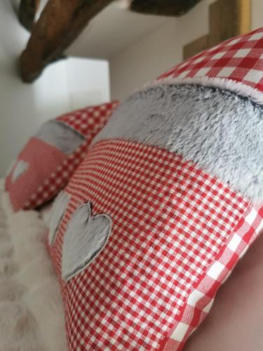 a red and white checkered pillow on a bed at Domaine de Pourrouquet - Demeure de charme et Gîte in Vic-Fezensac