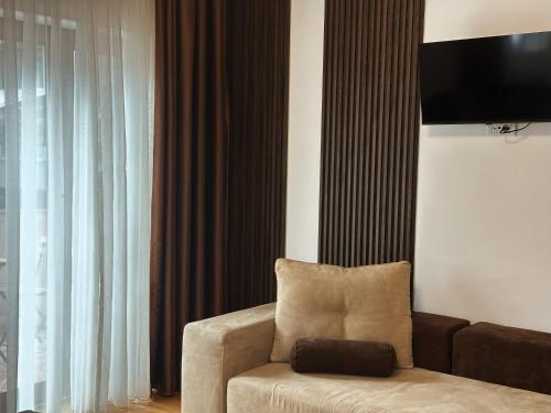 a living room with a couch and a television at Hillside Garden by Sienna in Skopje