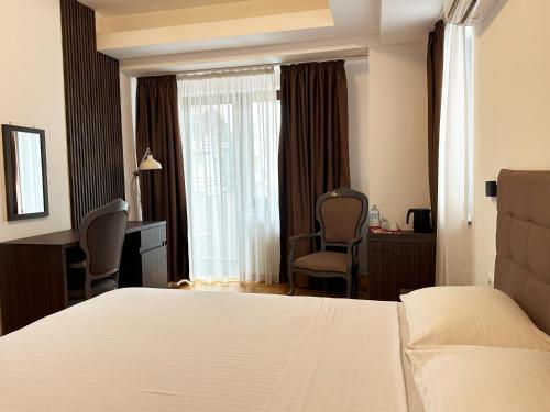 a hotel room with a bed and a window at Hillside Garden by Sienna in Skopje