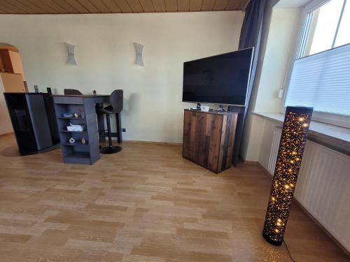 a living room with a flat screen tv and a table with lights at Carpe Diem Wellness Ferienwohnung in Illingen
