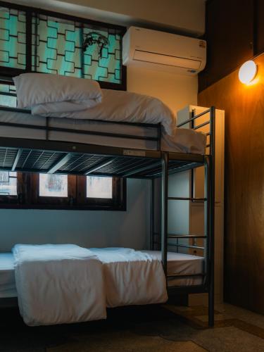 two bunk beds in a room with a wall at MornSamyan in Bang Rak