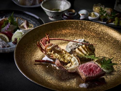 a plate of food with crabs and meat on a table at Isaribinoyado Seaside Kancho in Wakayama