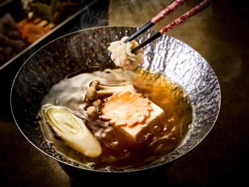 a bowl of food with a drink in it at Isaribinoyado Seaside Kancho in Wakayama