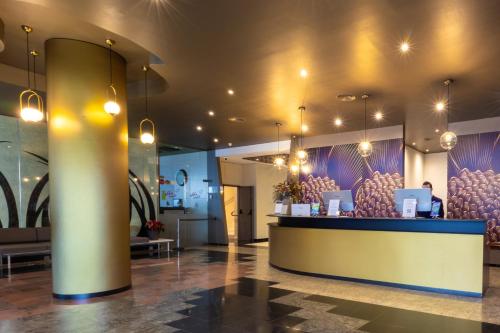 a lobby with a bar with purple walls and lights at Abba Garden in Barcelona