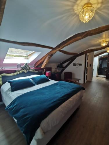 a bedroom with a large bed with blue sheets at Domaine de Pourrouquet - Demeure de charme et Gîte in Vic-Fezensac