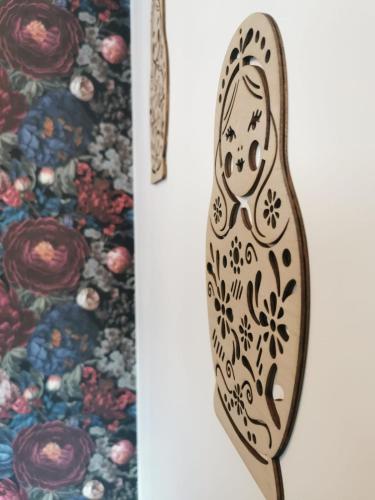 a wooden spoon with a pattern on it next to a floral rug at Domaine de Pourrouquet - Demeure de charme et Gîte in Vic-Fezensac