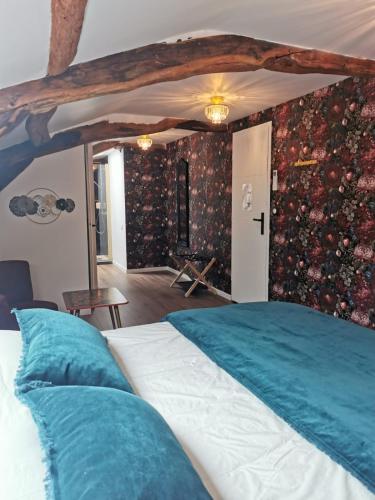 a bedroom with a large bed with blue pillows at Domaine de Pourrouquet - Demeure de charme et Gîte in Vic-Fezensac