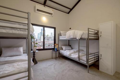 a bedroom with two bunk beds and a window at MornSamyan in Bang Rak