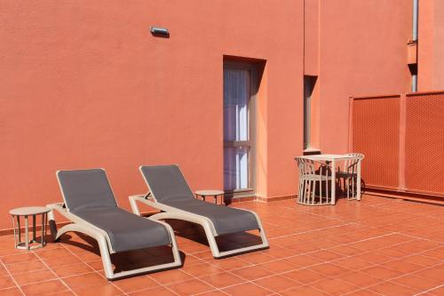 two chairs sitting in a room with an orange wall at Abba Garden in Barcelona