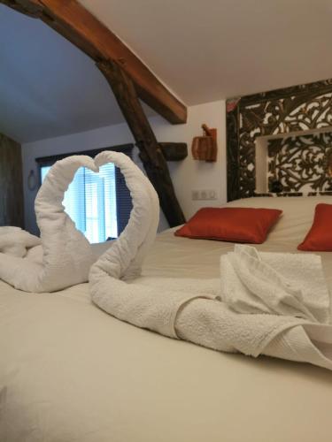 a bed with a heart made out of towels at Domaine de Pourrouquet - Demeure de charme et Gîte in Vic-Fezensac