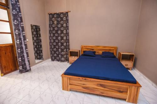 a bedroom with a bed with a blue mattress at Petit Havre de paix avec jardin - Centre Ville in Diego Suarez