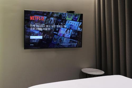 a flat screen tv hanging on a wall at Pangyo Business & Tourist Hotel KYND in Seongnam