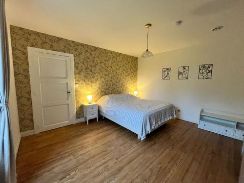 a small bedroom with a bed and a door at Domaine de Pourrouquet - Demeure de charme et Gîte in Vic-Fezensac