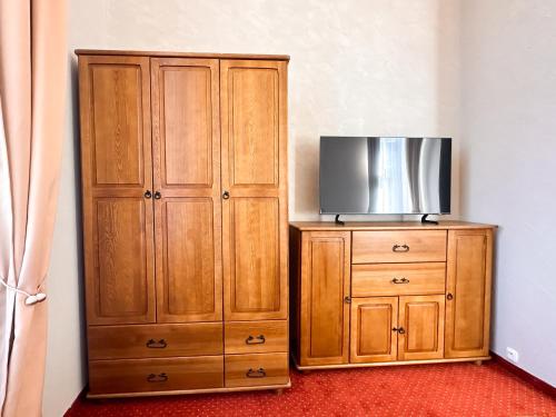 a wooden cabinet with a television on top of it at Vila Černý leknín in Tábor