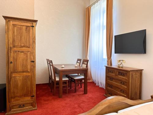 a room with a table and chairs and a television at Vila Černý leknín in Tábor