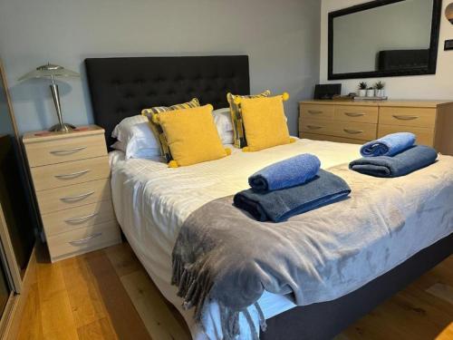 a bedroom with a large bed with yellow and blue pillows at Modern 1-Bedroom Apartment in Holt in Holt