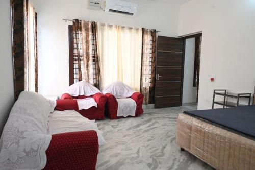 a bedroom with two beds and a couch at The Villas Homestay in Jammu