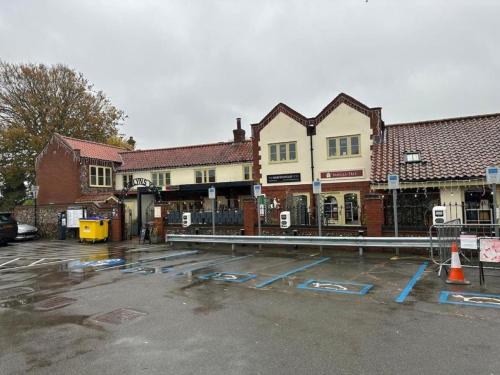 an empty parking lot in front of a building at Modern 1-Bedroom Apartment in Holt in Holt