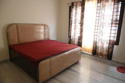 a bed sitting in a room with a window at The Villas Homestay in Jammu