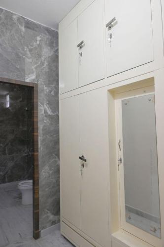 a bathroom with white cabinets and a toilet at The Villas Homestay in Jammu