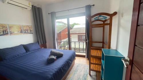 een slaapkamer met een blauw bed en een balkon bij Happy House in Chaloklum in Chaloklum