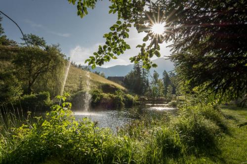 a waterfall over a river with the sun in the background at Ferienhaus Oetztal in Sautens