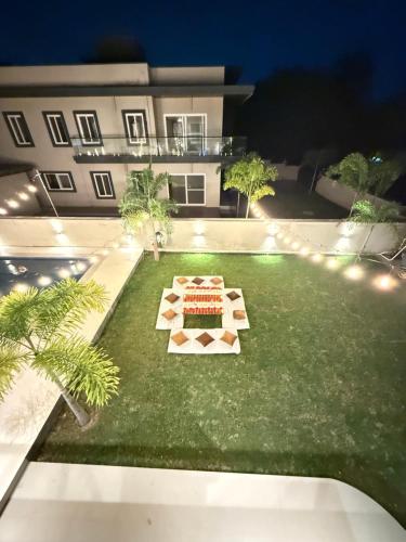 a lawn with a cake on it in front of a building at Fari villa-Luxury Stay & Pool in Moinabad