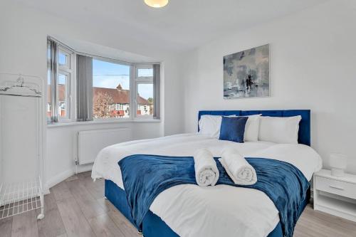a bedroom with a blue and white bed and a window at 7 Beds, 4 Bedrooms, Parking, Close to Station in Parkside