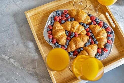 a tray with a plate of croissants and berries at 7 Beds, 4 Bedrooms, Parking, Close to Station in Parkside