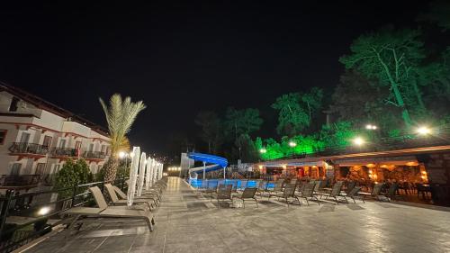 a group of chairs sitting on a patio at night at Casa De Levıssı Ölüdeniz in Oludeniz