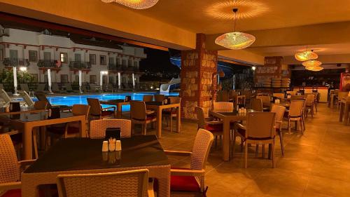 a restaurant with tables and chairs and a pool at Casa De Levıssı Ölüdeniz in Oludeniz