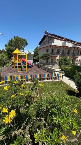a playground in a yard with a house in the background at Casa De Levıssı Ölüdeniz in Oludeniz
