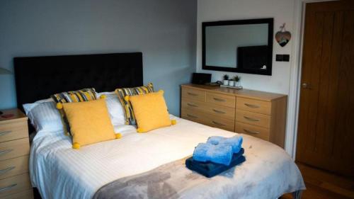 a bedroom with a large bed with yellow and blue pillows at Modern 1-Bedroom Apartment in Holt in Holt