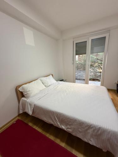 ein weißes Bett in einem Zimmer mit Fenster in der Unterkunft ViA prime central location in Ohrid