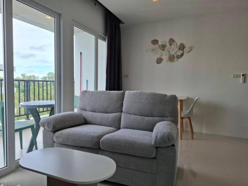 a living room with a couch and a table at BEACH Condo Mae Phim in Ban Tha Fat