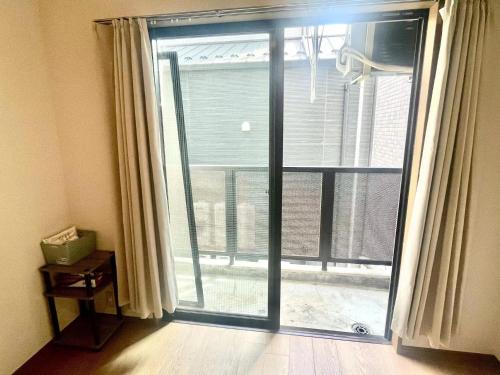 a sliding glass door with a view of a balcony at Tokyo West Shinjuku close to Shinjuku Chuo Park in Tokyo