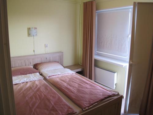 a small bedroom with two beds in front of a window at Orissaare Apartment in Orissaare