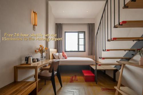a bedroom with a bed and a desk and a staircase at 上海浦东机场华美达安可酒店-免费提供24小时浦东机场班车十分钟到达候机楼出发层 in Shanghai