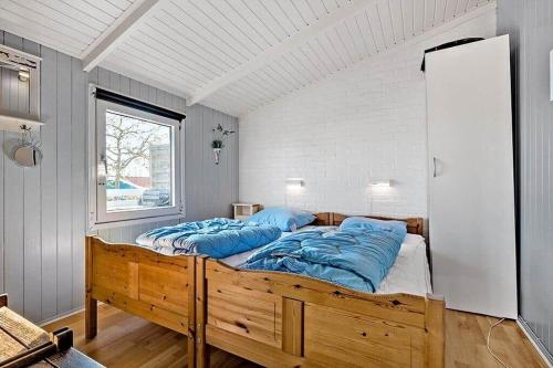 a bedroom with a large bed with blue pillows at 6630-Allinge-Madselokke-5-Hus-45 in Allinge