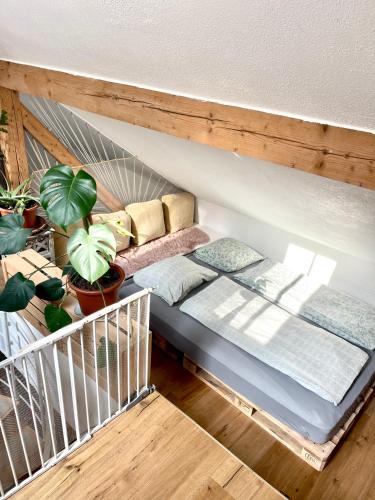 a bed in a room with pillows and plants at Barn Apartment in an Old Farmhouse near Vaduz in Sevelen