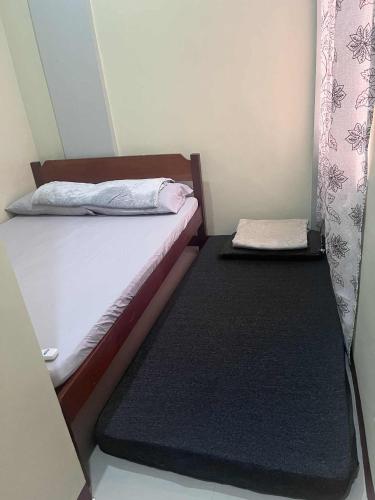 a pair of beds in a small room at Ace Transient in Puerto Princesa City