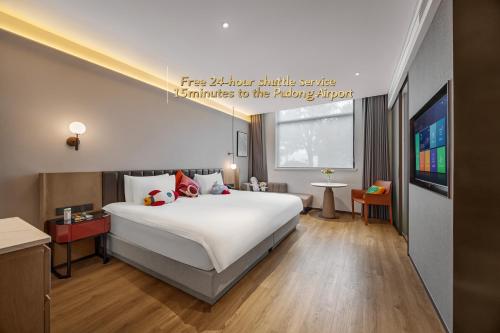 a hotel room with a large bed and a tv at 上海浦东机场华美达安可酒店-免费提供24小时浦东机场班车十分钟到达候机楼出发层 in Shanghai