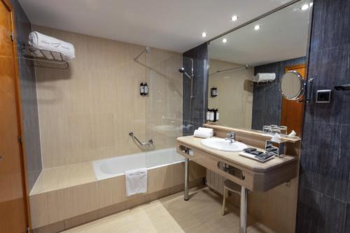 a bathroom with a tub and a sink and a shower at Abba Garden in Barcelona