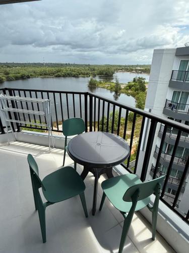 a balcony with a table and chairs and a view of a river at BEACH Condo Mae Phim in Ban Tha Fat